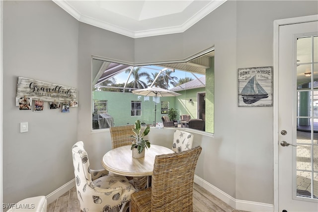 dining area with a wealth of natural light, light hardwood / wood-style floors, and ornamental molding