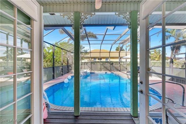 view of pool featuring a lanai, a pool with connected hot tub, and fence