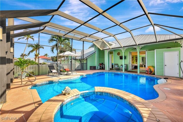 view of pool with an in ground hot tub, a patio, ceiling fan, and a lanai