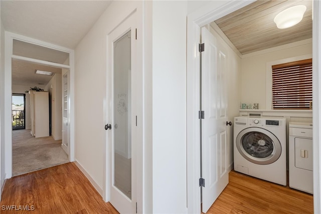 laundry room with washer and clothes dryer, plenty of natural light, and light hardwood / wood-style floors