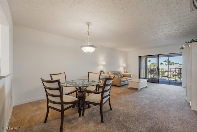 dining area featuring a textured ceiling and light carpet