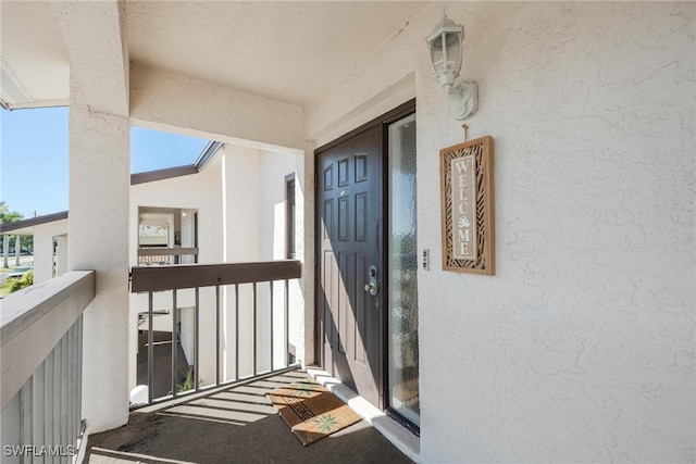 view of exterior entry featuring a balcony