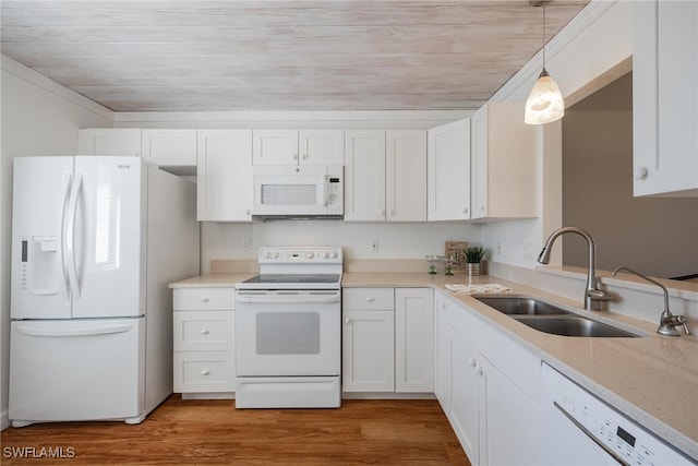 kitchen featuring sink, hanging light fixtures, hardwood / wood-style floors, white appliances, and white cabinets