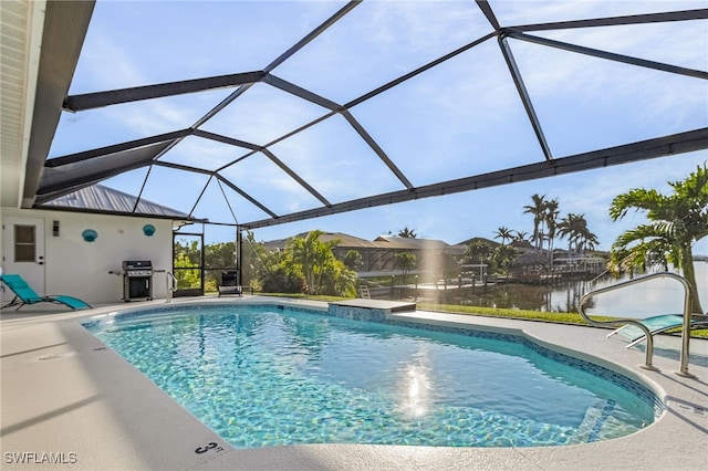 view of pool with area for grilling, a patio, a water view, and glass enclosure