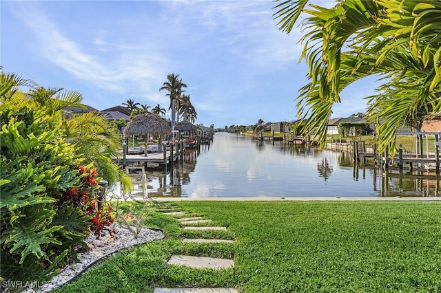 view of dock featuring a lawn and a water view