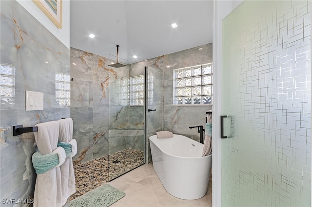 bathroom with tile walls and shower with separate bathtub