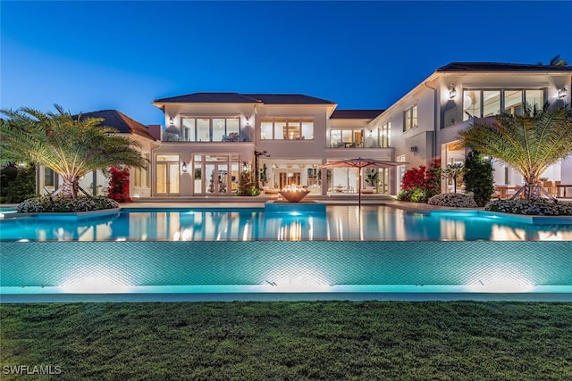 view of pool with french doors and a lawn