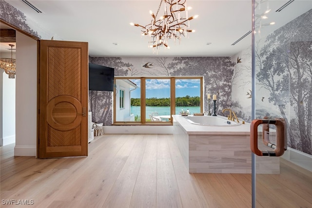 bathroom with wood finished floors, a garden tub, and wallpapered walls