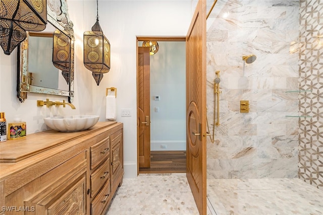 full bath featuring a tile shower and vanity