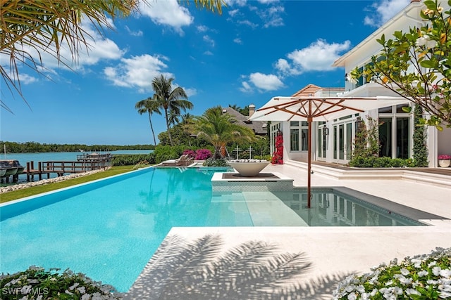 outdoor pool featuring a water view and a patio area