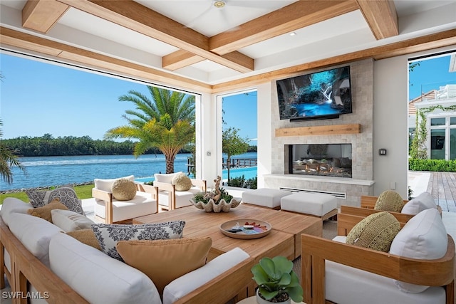 sunroom with coffered ceiling, a water view, a fireplace, and beamed ceiling