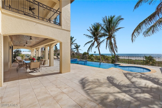 view of pool featuring a patio, a water view, and ceiling fan