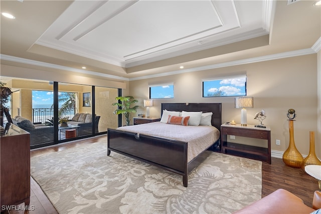 bedroom featuring a raised ceiling, ornamental molding, and hardwood / wood-style flooring