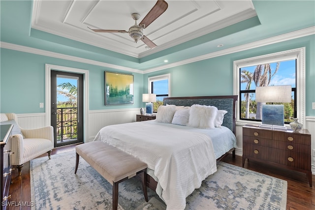 bedroom featuring ceiling fan, dark wood-type flooring, access to outside, and a tray ceiling