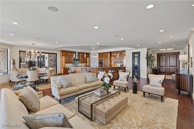 living room with an inviting chandelier, ornamental molding, and hardwood / wood-style flooring