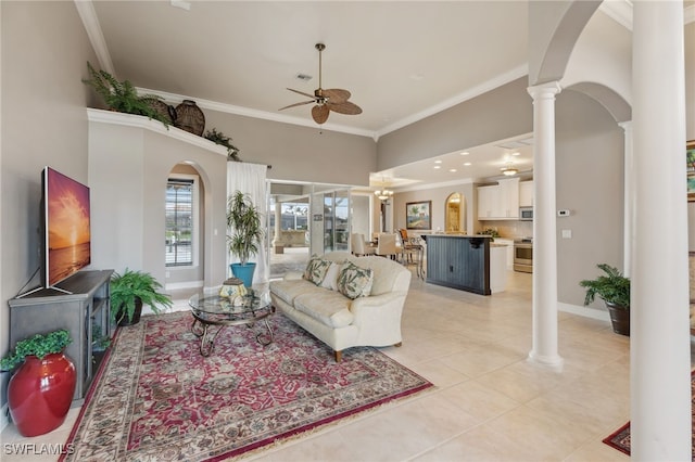 living room featuring a high ceiling, ceiling fan, ornamental molding, light tile patterned floors, and decorative columns