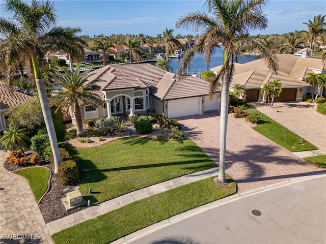 view of front of property with a water view, a front yard, and a garage