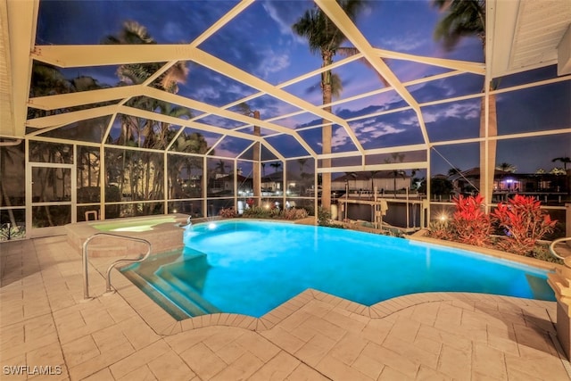 pool at dusk featuring a water view