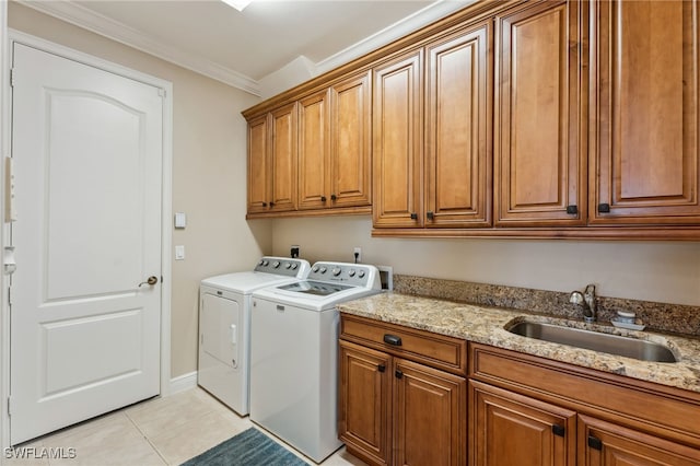 laundry area featuring sink, cabinets, separate washer and dryer, crown molding, and light tile patterned floors