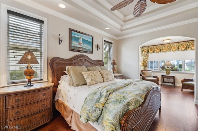 bedroom featuring dark hardwood / wood-style floors, crown molding, and multiple windows