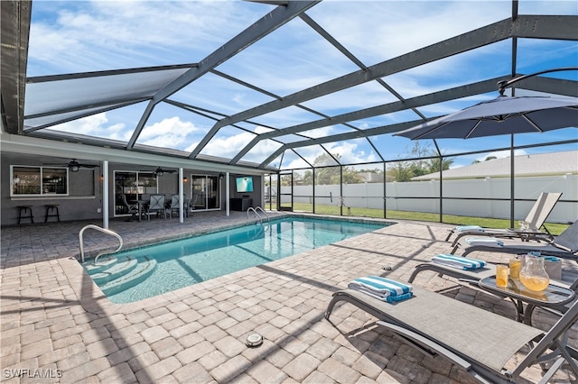 view of swimming pool featuring a patio, ceiling fan, and a lanai