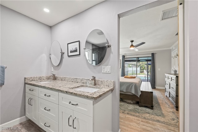 bathroom with wood-type flooring, vanity, ceiling fan, and crown molding