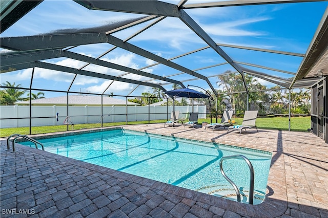 view of swimming pool featuring a patio, a lanai, and a lawn