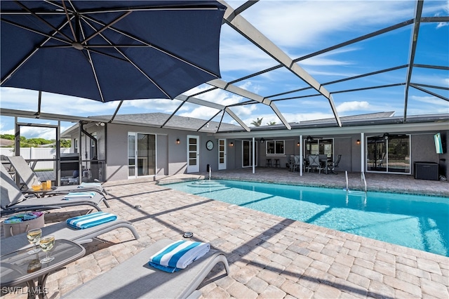 view of swimming pool featuring ceiling fan, a lanai, and a patio