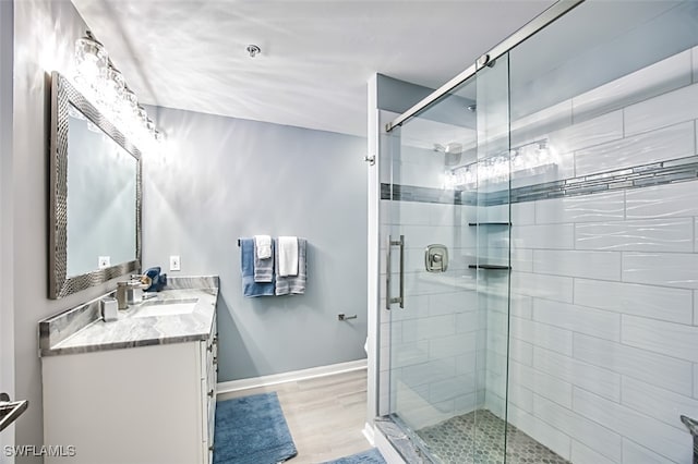 bathroom featuring wood-type flooring, vanity, and a shower with door