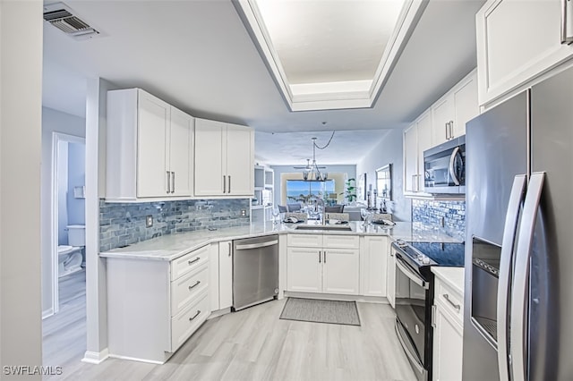 kitchen with white cabinets, stainless steel appliances, and tasteful backsplash