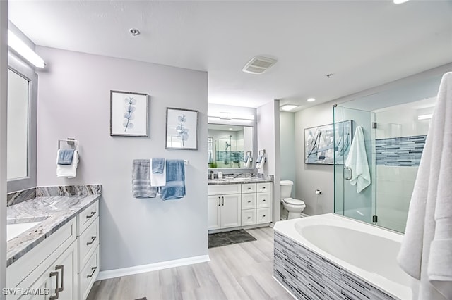 full bathroom featuring hardwood / wood-style floors, vanity, separate shower and tub, and toilet