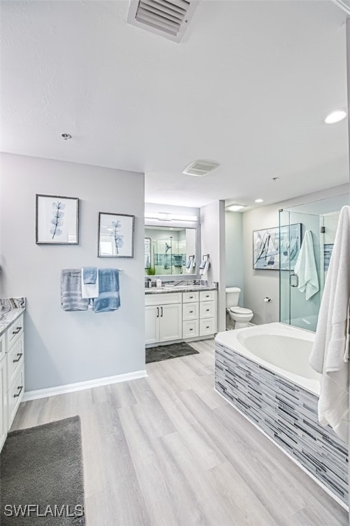 bathroom featuring hardwood / wood-style floors, vanity, toilet, and a bathtub