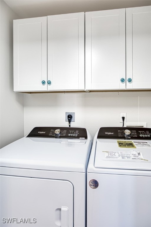 laundry room featuring washer and dryer and cabinets