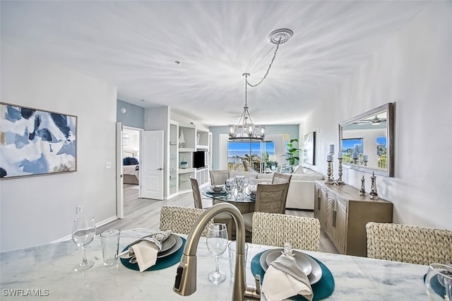 dining room featuring a chandelier, a healthy amount of sunlight, and light hardwood / wood-style flooring