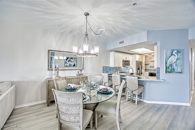 dining space with an inviting chandelier and light wood-type flooring