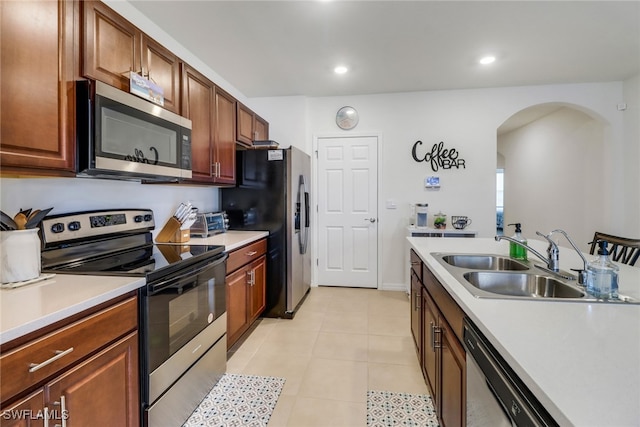 kitchen with sink, light tile patterned flooring, and stainless steel appliances