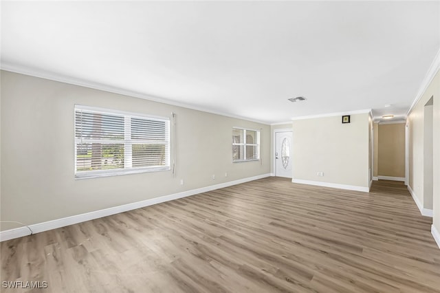 spare room featuring wood-type flooring and crown molding