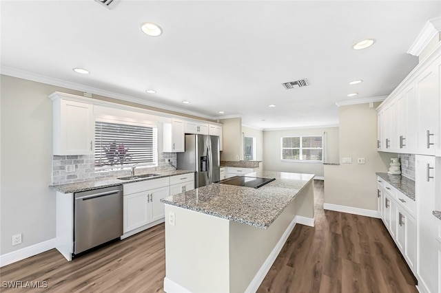 kitchen with white cabinetry, a wealth of natural light, and appliances with stainless steel finishes