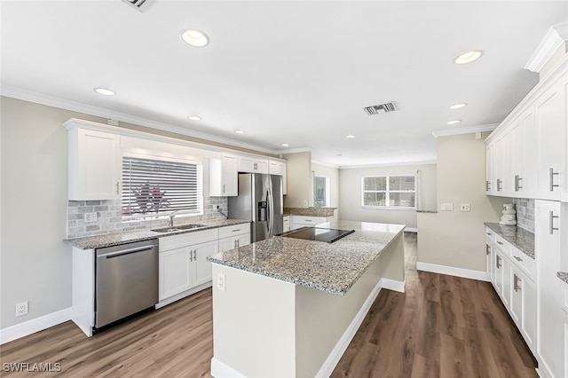 2199 Santiago Ave, Fort Myers, FL 33905 - kitchen featuring stainless steel appliances, a kitchen island, tasteful backsplash, crown molding, and white cabinetry