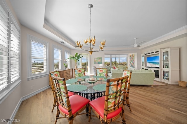 dining room featuring crown molding, a healthy amount of sunlight, ceiling fan with notable chandelier, and light wood-type flooring