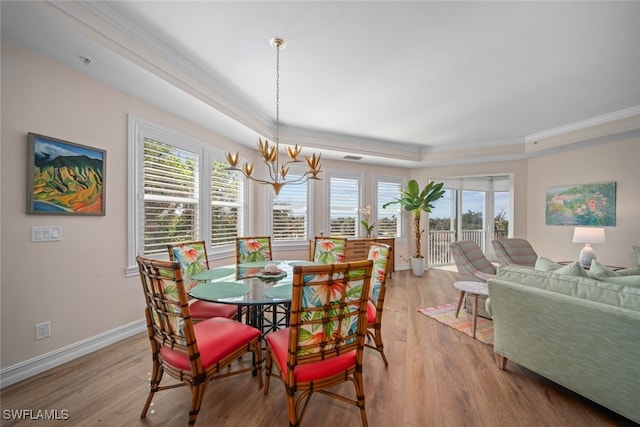 dining room featuring ornamental molding, light hardwood / wood-style floors, a wealth of natural light, and a notable chandelier