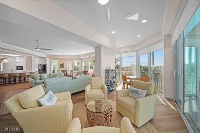 living room featuring ceiling fan, a healthy amount of sunlight, and light hardwood / wood-style flooring