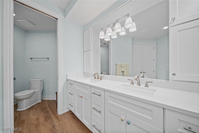 bathroom with hardwood / wood-style floors, vanity, and toilet