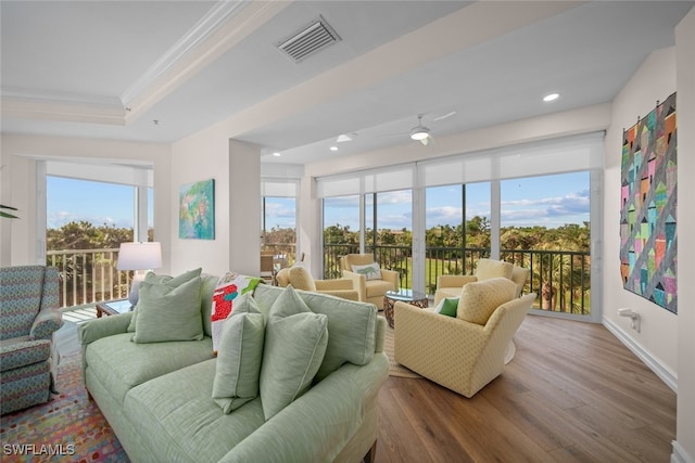 living room with hardwood / wood-style floors, ceiling fan, and ornamental molding