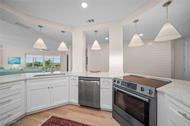 kitchen featuring white cabinetry, pendant lighting, stainless steel appliances, and sink