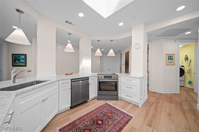 kitchen with sink, kitchen peninsula, appliances with stainless steel finishes, white cabinets, and light wood-type flooring