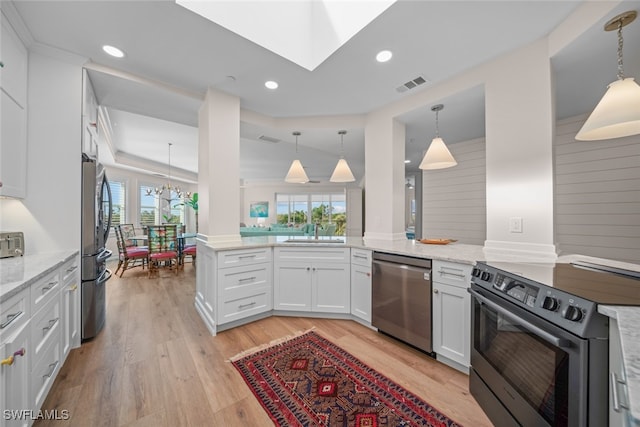 kitchen featuring kitchen peninsula, appliances with stainless steel finishes, white cabinetry, and a healthy amount of sunlight