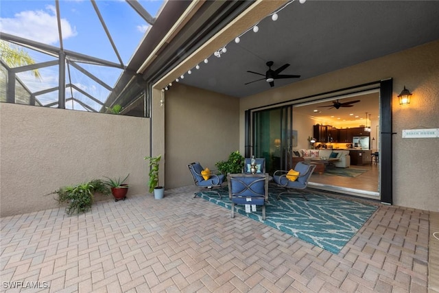 view of patio / terrace featuring glass enclosure and ceiling fan