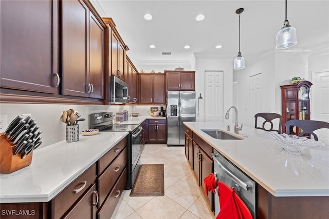 kitchen featuring ornamental molding, stainless steel appliances, sink, pendant lighting, and a center island with sink