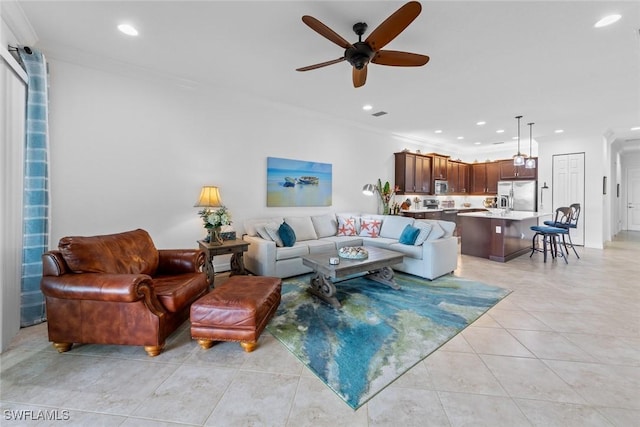 tiled living room featuring ceiling fan and ornamental molding